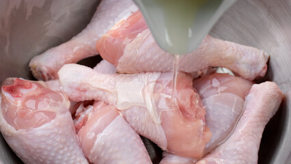 Process marinated raw chicken legs in olive oil