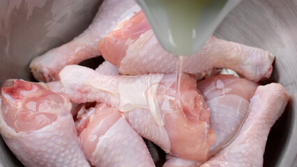 Fototapeta premium Process marinated raw chicken legs in olive oil