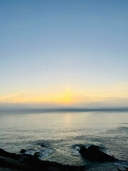 Orange sea horizon, rocky coast, evening seascape background