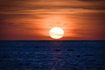 Sunset over the Baltic Sea. The red sun sinks into the sea. Evening atmosphere
