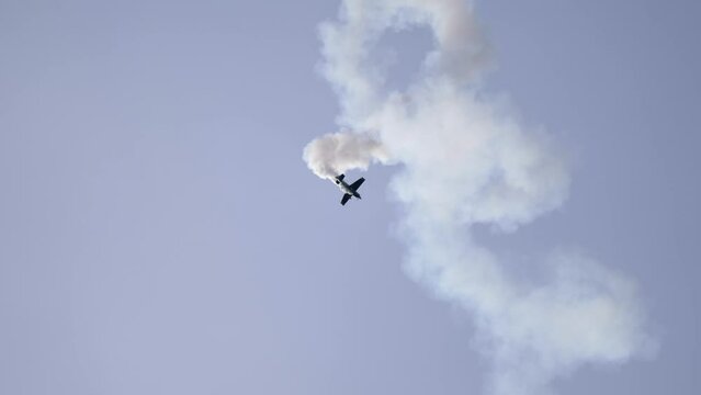 Corkscrewing Aerobatic Airplane Spiraling Down with Smoke Trail at Airshow