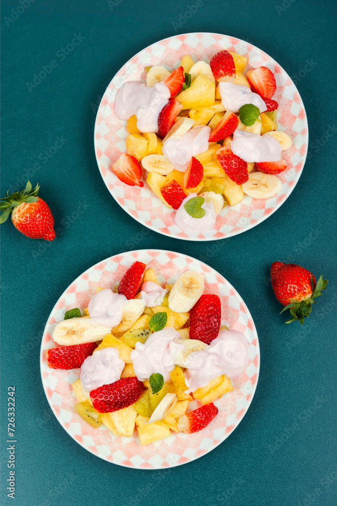 Wall mural Fruit salad with yogurt on a plate.