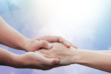 Two people holding hand together over blurred nature background,Business man and woman shaking hands,helping hand  and world peace concept with copy space