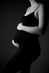 Silhouette and close up photo of a young pregnant woman in the black overall