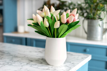 Spring flowers in glass vase on wooden table in kitchen. Bouquet of white and pink tulips. Contemporary elegant scandi interior. Space for text. Home comfort. International Women's Day on March 8