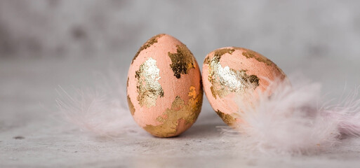 Stylish Peach Fuzz Easter eggs with a coating of golden sweat on a gray background. The concept of...