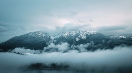 Beautiful snowy mountains of British Columbia, Canada, covered in clouds. Taken near Vancouver, during a cloudy evening before sunset.