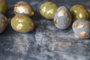 Stylish beautiful Easter eggs with golden potali coating on a gray background. The concept of happy...