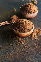 Muscovado brown sugar in wooden  bowl on rusty table  background.