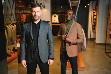 Two handsome respectable men in elegant classic suits in a premium men's clothing store