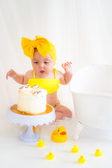 Girl in a yellow swimsuit and birthday cake