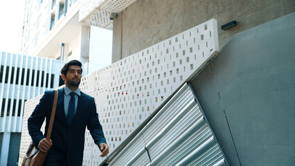 Smart business man walking up the stairs with confident near building. Skilled project manger...