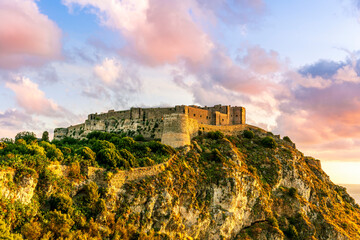 majestic evening landscape of beautiful old ancient castle on a mountain during beautiful sunset or...