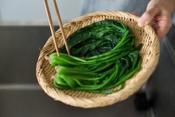 茹で上がったほうれん草をざるにあげるところ
