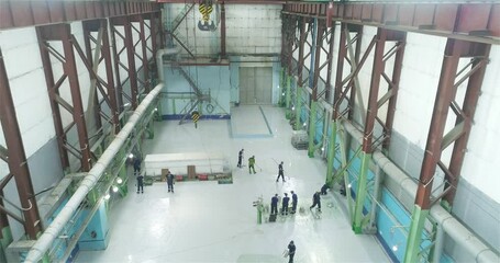 A team of professionals makes a polymer floor in a factory workshop. A team of builders makes heavy Duty Industrial Floor Coatings.