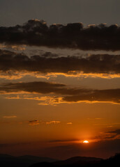 Beautiful sunset in the mountains. Sunset View from the Top of a Mountain. Sunset in strong orange tones in Serbia. The sun falls for horizon, a sunset. Shadows are condensed, beautiful clouds. 