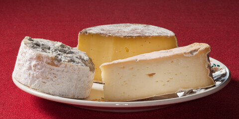 Trois fromages posés sur une assiette blanche