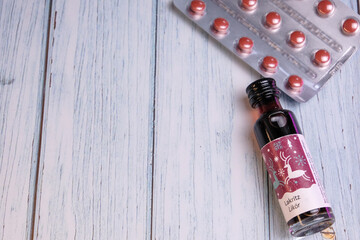 Tiny bottle of lakritz licorice liqueur with red suppliment pills on the back