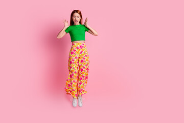Full size photo of astonished stunned girl wear stylish top print pants flying look down at empty...