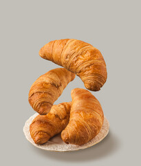 Flying croissants on gray background