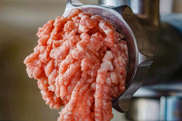 Beef minced meat preparation. Homemade minced beef in a meat grinder, close up selective focus