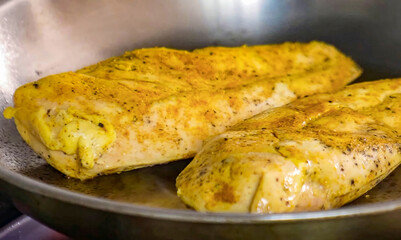 Chicken fillet with spices on a hot frying pan. Homemade roasted chicken, serving food for restaurant, menu, advert or package, close up, selective focus