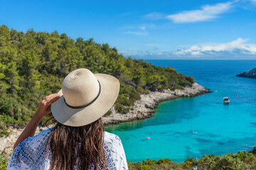 Rear view of young female wearing hat looking at amazing Zitna beach in Zavalatica, Korcula, Croatia - obrazy, fototapety, plakaty