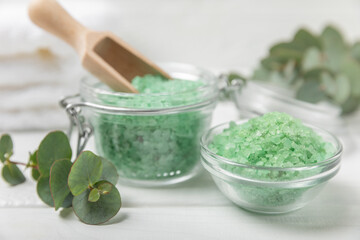 Cosmetic sea salt with aroma and eucalyptus extract on a textured wooden background with branches of fresh aromatic eucalyptus.Spa concept. Bath salt. Close-up. Space for text.Body care.copy space