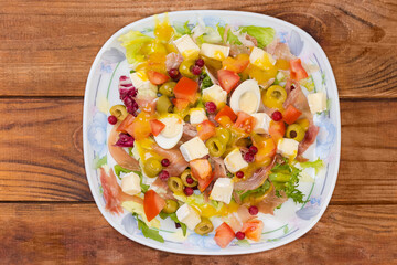 Salad of jamon with quail eggs, cheese, greens, vegetables serving