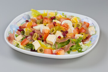 Salad of jamon with quail eggs, cheese, greens and vegetables