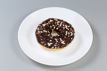 Doughnut with chocolate filling and glaze and sprinkles on dish