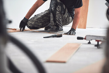 Professional handyman installing laminate flooring in a new apartment. - Powered by Adobe