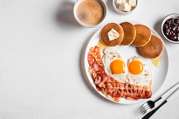 Breakfast with fried eggs, bacon and pancakes