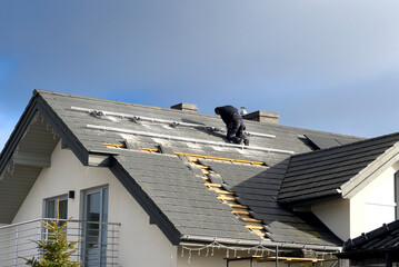 Workers installing modern solar panels on the roof of a house. Ecology and alternative energy concept.