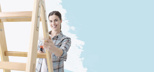 Young woman painting her home