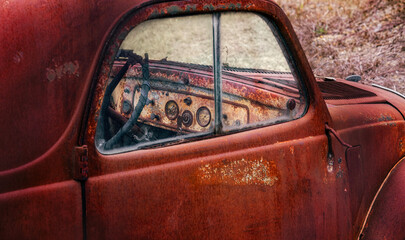 Interior view of the dash board of an old junked retro vehicle in a junkyard