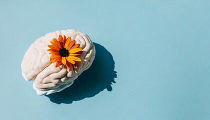 Human brain with spring orange flower on blue background. Mental health, self care and happiness