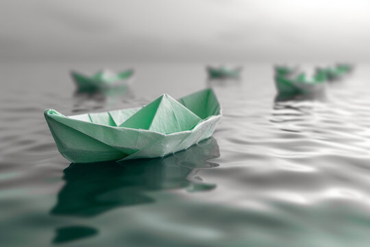 handmade green paper boat floats on a calm body of water, leading a fleet, signifying leadership and tranquility