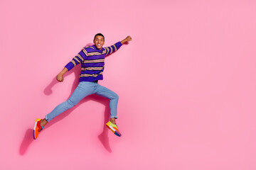 Full body photo of attractive young man jumping flying superhero dressed stylish violet striped...