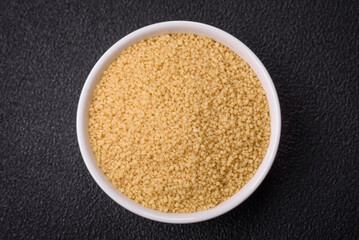 Wheat porridge couscous grains on a dark concrete background