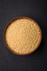 Wheat porridge couscous grains on a dark concrete background