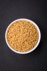 Ptitim wheat porridge grains on a dark concrete background