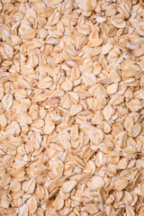 Raw oatmeal flakes in a ceramic bowl on a dark concrete background
