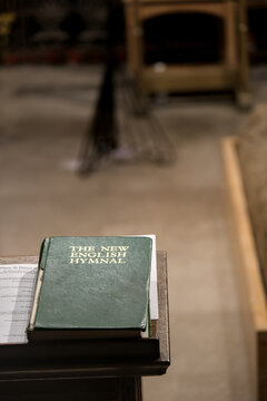 The New english hymnal, in the left corner of the image, on a display of a church