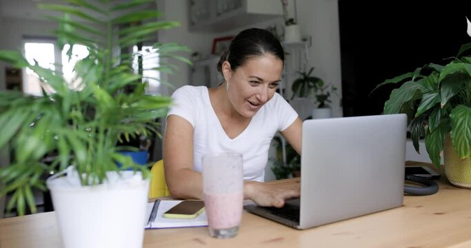 Businesswoman cheering after successfully finishing work at laptop