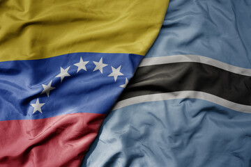 big waving national colorful flag of botswana and national flag of venezuela . macro