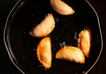 cooking food in a frying pan with boiling oil