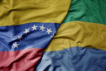 Fototapeta premium big waving national colorful flag of gabon and national flag of venezuela . macro