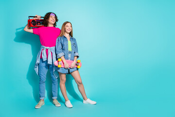 Full body photo of teen curly guy with blonde girlfriend holding boombox player and skate looking...