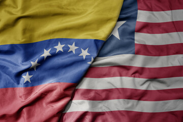 big waving national colorful flag of liberia and national flag of venezuela . macro
